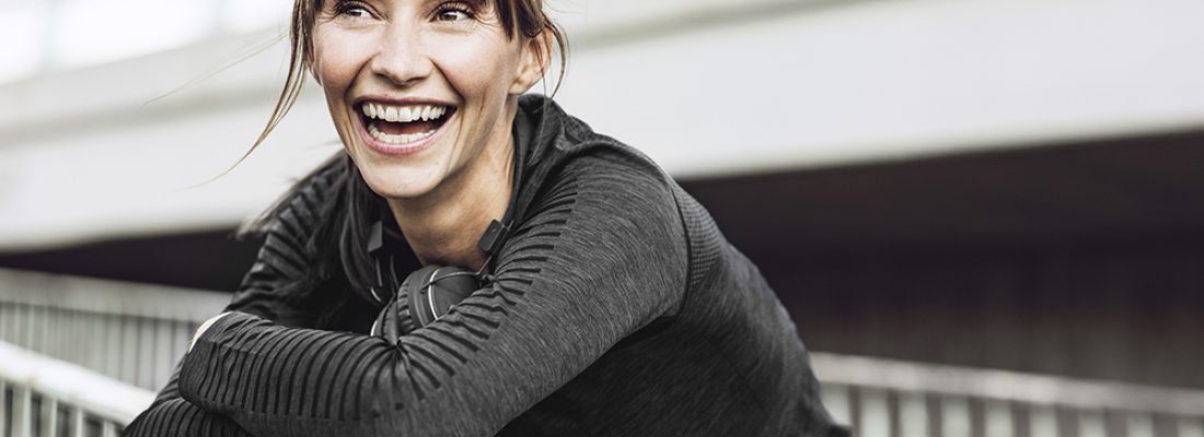 Sportive woman with headphones, doing her fitness training outdoors